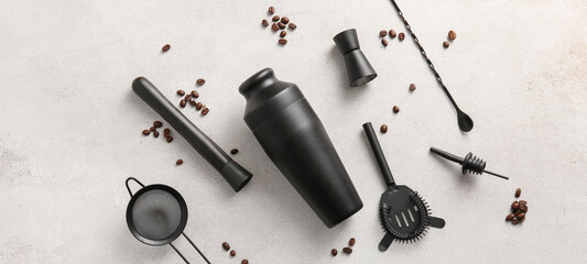Different bartender's utensils and coffee beans on light background