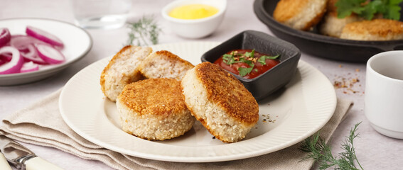 Plate with tasty meat cutlets and sauce on white background