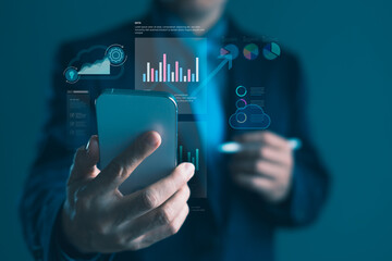 Businessman using smartphone with virtual dashboard and data analytics interface for cloud computing, performance monitoring, and digital business strategy