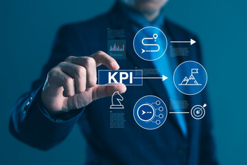 Businessman touching KPI icon with digital strategy, goals, and performance graphics for business success and management improvement concept