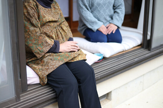 縁側に座ってお茶を飲む女性