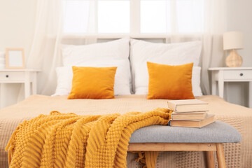 Yellow plaid with books on soft bench in bedroom, closeup