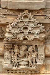 Ornate Stone Carving of a Deity and Figures within a Decorative Niche of an Ancient Temple