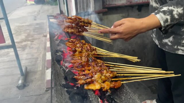 Vendor Grilling Indonesian Chicken Satay Skewers on Charcoal Fire with Smoke &ndash; Authentic Asian Street Food BB