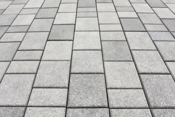 Fototapeta premium Close-up of cement block pavement showing detailed texture and geometric pattern, durable, urban outdoor, modern design