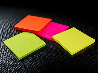 Fototapeta premium Four colorful sticky notes on a dark textured surface