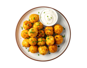 Crispy, golden-brown bite-sized balls atop a plate, with a side of creamy sauce