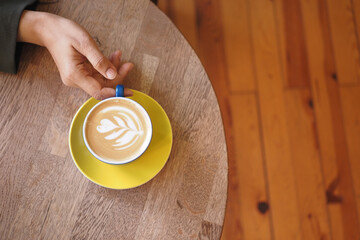 Enjoying a cup of latte art on a cozy wooden table
