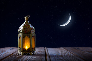 Ornate Islamic lantern glowing on a wooden table under a starry night sky light isolated on a transparent background