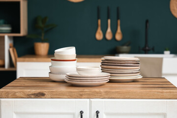 Stacks of plates and bowls on table in kitchen