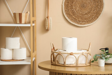 Basket with rolls of toilet paper on table in restroom, closeup