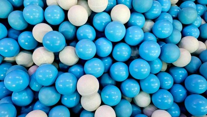 Abstract texture made of blue and white plastic balls tightly arranged together. Suitable for graphic design, wallpaper, pattern creation, advertising, digital art, and website decoration.