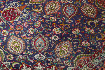 Detail of persian carpet macro: floral blue and red pattern texture
