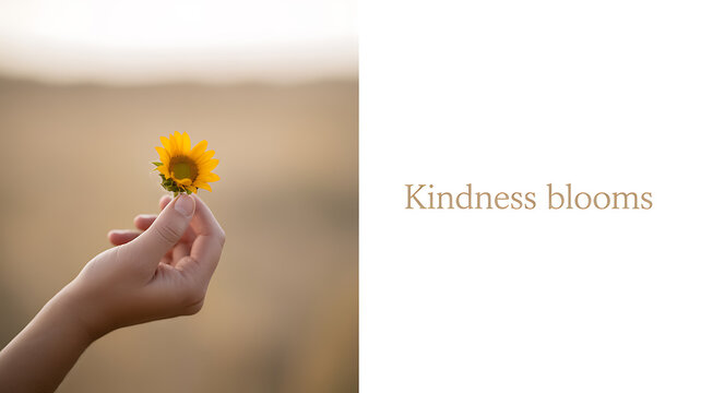 A hand holding a small sunflower against a blurred natural background with the text 'Kindness blooms' - Powered by Adobe