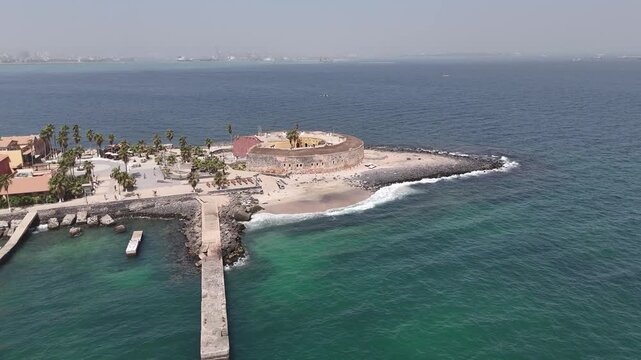Drone aerial of Gor&eacute;e Island pier and waterfront in Senegal, historic entry point to the island, UNESCO heritage symbol of African slave trade history