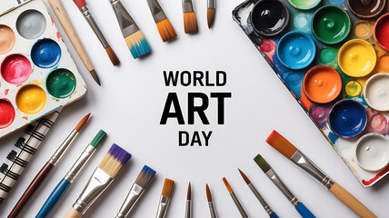 World Art Day celebration with paintbrushes, watercolor paints, and art supplies arranged on a white background