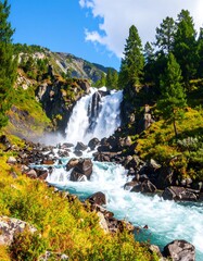 Mountain waterfall cascading over rocky terrain. Lush greenery surrounds the water's edge, with towering pine trees on the hills. Bright sunlight illuminates the scene under a partly cloudy sky