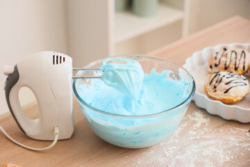 Mixer with whipped blue egg albumen on table in kitchen