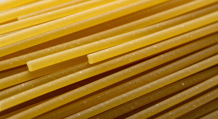 Close-up captures the dense arrangement of uncooked spaghetti, highlighting the vibrant yellow color and smooth texture, evoking feelings of anticipation and culinary delight, presented with a stark
