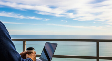 man working remotely with coffee and sea view