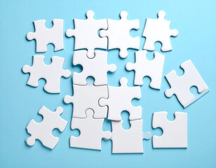 White puzzle pieces scattered on a light blue surface