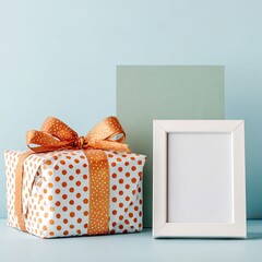 A gift box with orange ribbon and polka dots, next to a white frame, against a muted background
