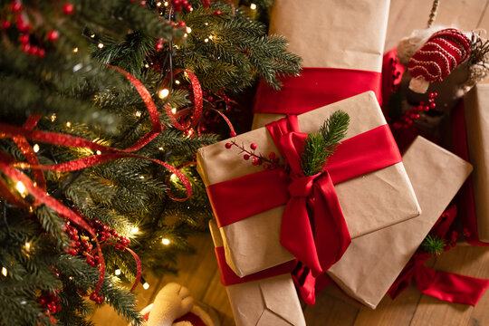 Christmas presents in a box with a red ribbon lie under the Christmas tree	 - Powered by Adobe