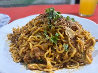 Indonesian bakmie goreng fried noodles with garnish  
