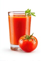 Fresh tomato juice in a glass, next to a whole tomato