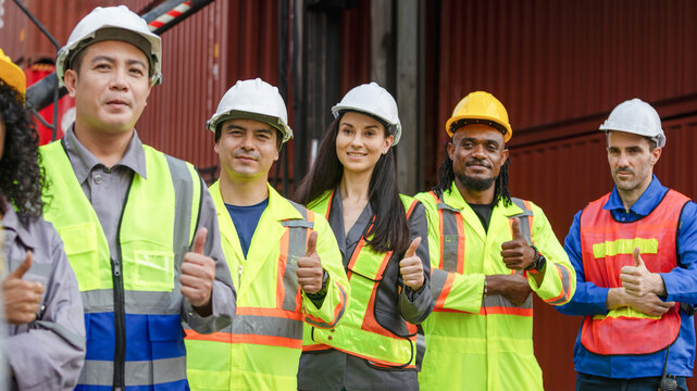 Diverse Team of Warehouse and Logistics Workers Giving Thumbs Up, Portrait of Multi-Ethnic Group of Industrial Engineers and Staff, Successful and Confident Colleagues in Shipping Container Yard