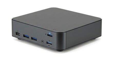 Fototapeta premium A gray compact computer with various ports visible on the front panel resting on a white surface