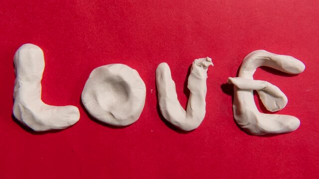 Claymation or clay stop-motion of a heart-shaped turn into the word &ldquo;love&rdquo; and stretched to fill the frame