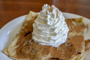 Crepe on Plate Topped with Whipped Cream and Cinnamon