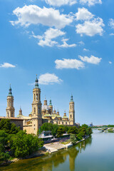 Basilica del Pilar reflecting on ebro river under blue sky in zaragoza