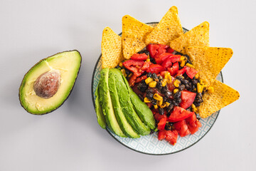 healthy nachos with corn black beans tomato avocado and corn chips