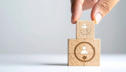 Wooden blocks stacked, person icons, hand placing block