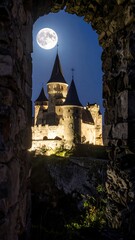 Castle viewed through a stone arch at night