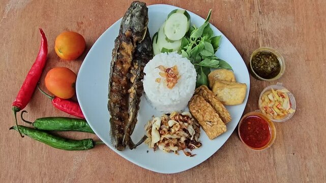 fresh vegetables on a plate,,Pecel lele set menu is deep fried Catfish served with rice,sliced cucumber,fresh indonesian basil and shrimp paste sambal or sambal terasi,additional menu fried tempeh and