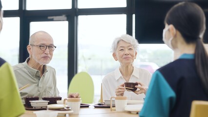 介護施設で食事をするアジア人高齢者