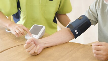 血圧を測るアジア人高齢者