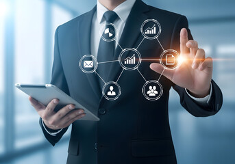 Businessman in a suit holding a tablet and interacting with a digital interface showing business analytics and icons