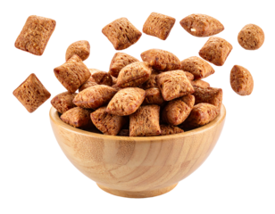 Brown cereal squares in a wooden bowl, flying