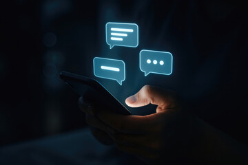 Hand holding smartphone with glowing chat bubbles mobile phone touching