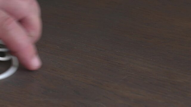 Man retrieves phone charger from table in indoor setting during daytime