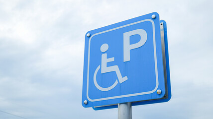 Blue sign with wheelchair icon showing a person ascending a slope, indicating accessibility ramp and dedicated passage for disabled individuals, symbolizing inclusion, safety, equality, and urban care
