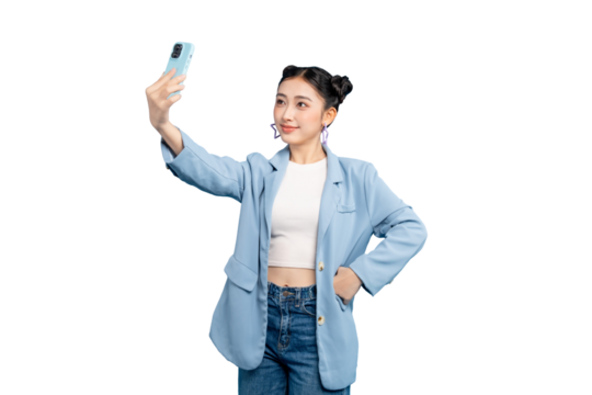 Portrait of Asian Woman taking a selfie with smartphone, posing for social media. She's stylishly dressed in a blue blazer and jeans in PNG
