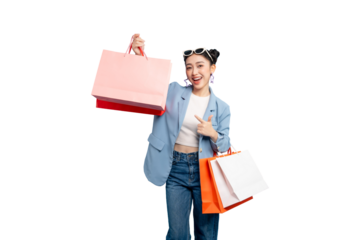 portrait Asian Woman  pointing while holding shopping bags in the sunlight. She is stylishly dressed, wearing sunglasses on PNG