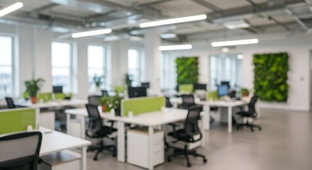 Blurred abstract background of a modern, clean, and white open-plan office with desks, computers, and green partition plants