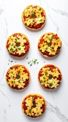 Five mini pizzas on bagels, arranged vertically on a marble surface, garnished with herbs