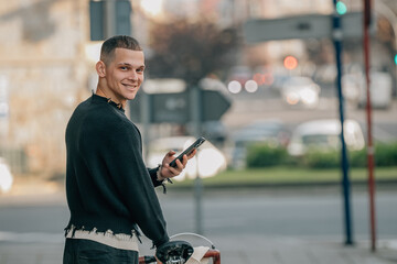 young man walking on the street with bicycle and mobile phone